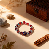 Blue and red glass beads of the ‘Sacred Echo’ bracelet with light and shadow play, symbolizing the balance between serene calm and vibrant vitality.