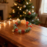 The‘Bedrock’bracelet on dark wood, showcasing the vibrant red agate and green crystal pairing that symbolizes strength, healing, and grounded stability.