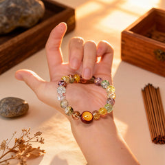 Holding the warm amber and multicolor glass bracelet close, a BodhiPulse companion for a mindful journey to inner peace and joy in the present moment.