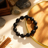 Ancient lotus seed mala bracelet for meditation, arranged with a book and tea to symbolize inner stillness and composure