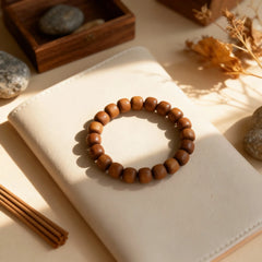 Close-up of the ‘Time Condensed’ sandalwood bracelet on a table, showcasing its rich wood grain and developing jade-like luster.