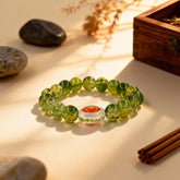 The serene ‘Infinite Clarity’ green glass bracelet on a wooden table, made from natural-inspired materials for mindfulness and blessings by BodhiPulse.