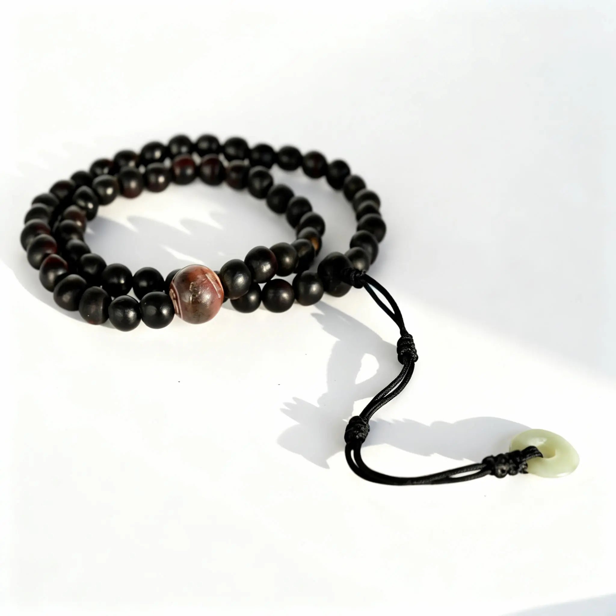 BodhiPulse Inner Flame Hand Mala - a 54-bead strand of deep soapberry and agate, a token of resilience and inner warmth.