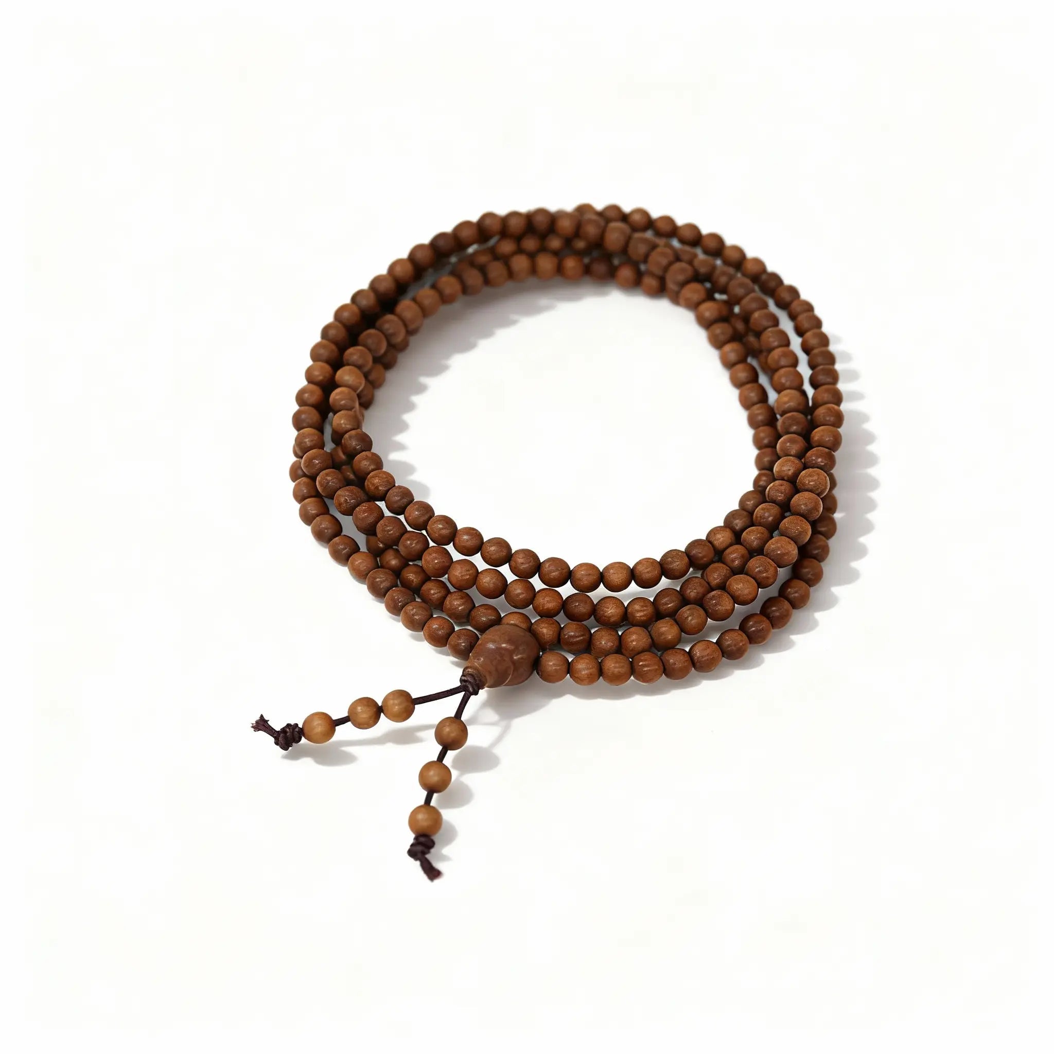 The full 108-bead sandalwood mala laid out as a single strand, showcasing each round bead’s grain and tone in harmony.