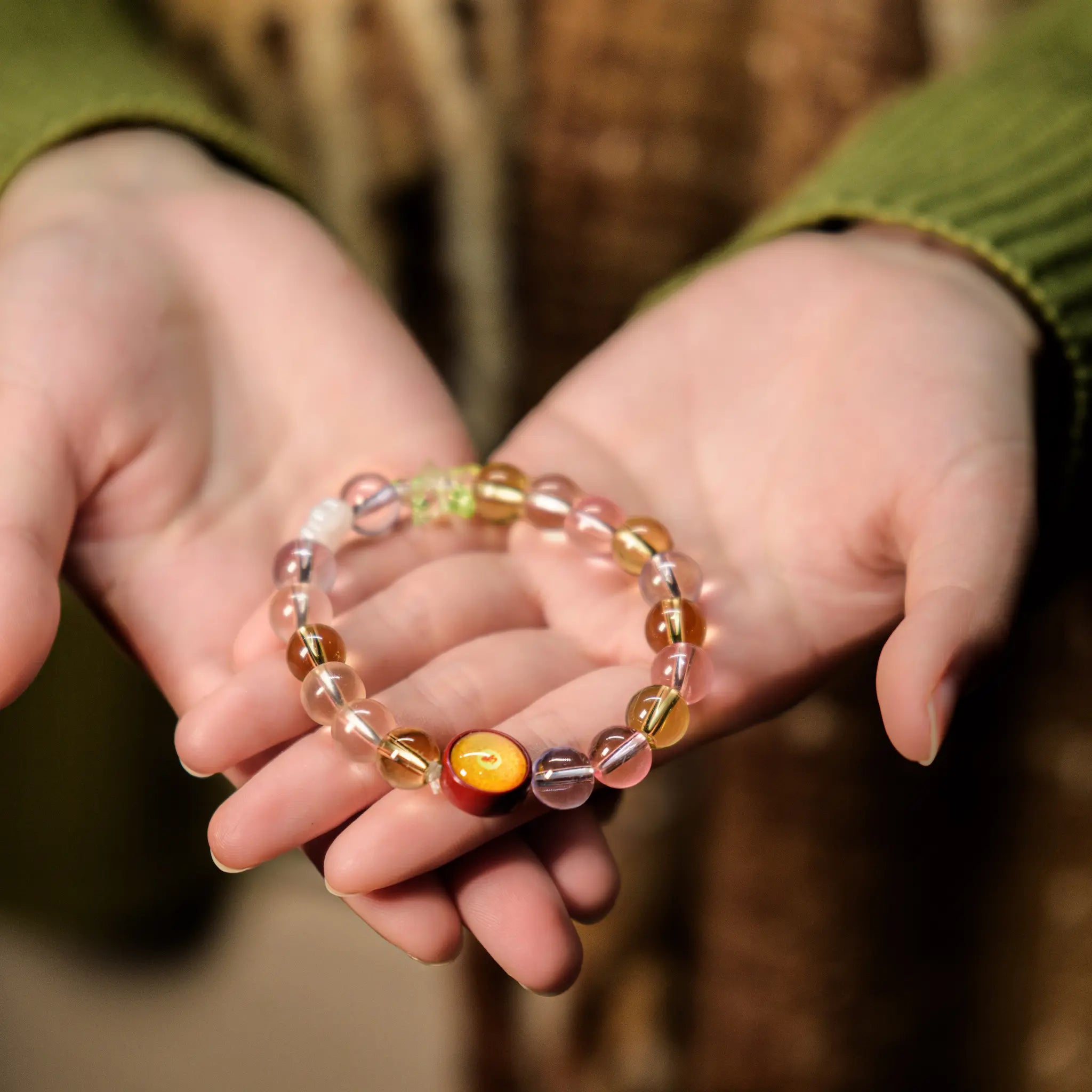 Gently cradling the colorful natural crystal bracelet in both hands, receiving its blessings for serenity and mindful healing with BodhiPulse.