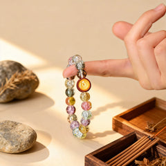 Holding the warm amber and multicolor glass bracelet close, a BodhiPulse companion for a mindful journey to inner peace and joy in the present moment.