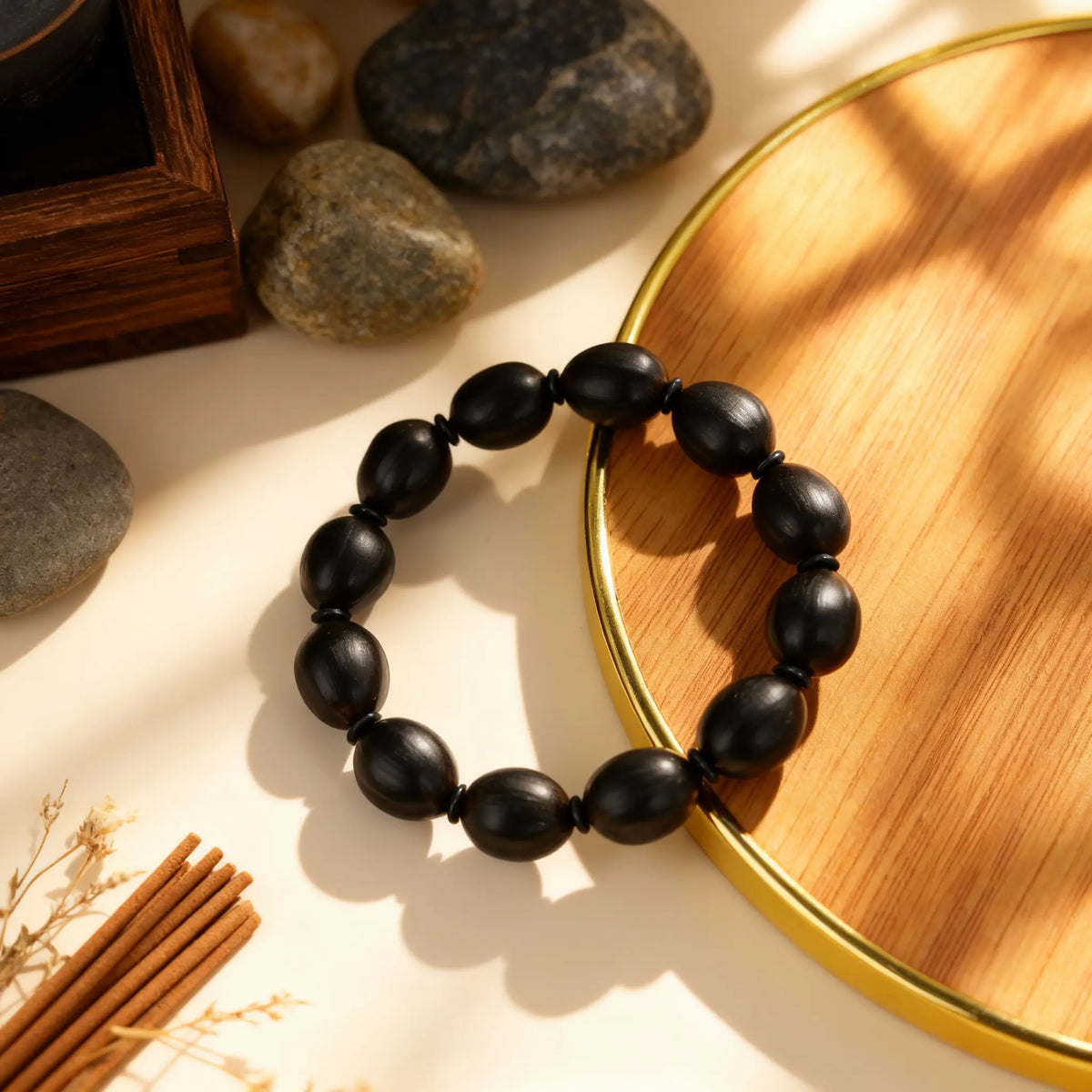 Ancient lotus seed mala bracelet for meditation, arranged with a book and tea to symbolize inner stillness and composure